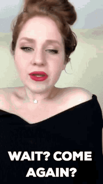 a woman with red hair and red lipstick is wearing a black off the shoulder top and a necklace .