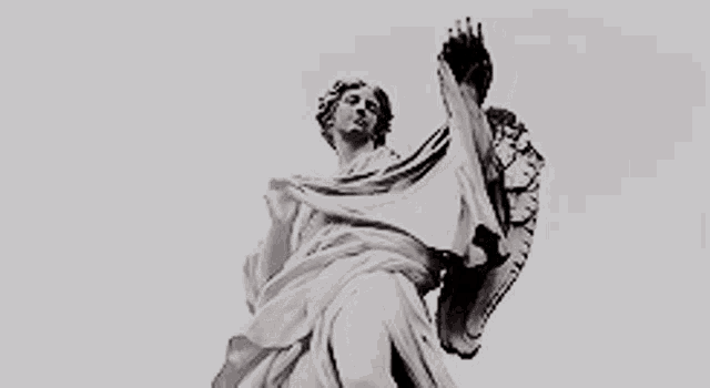 a black and white photo of a statue of a woman in a white dress holding a crown .