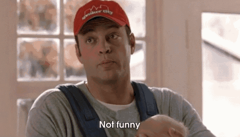 a man in a red hat is holding a baby and saying not funny .