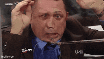 a man in a suit and tie is holding a spoon in his mouth and making a funny face .