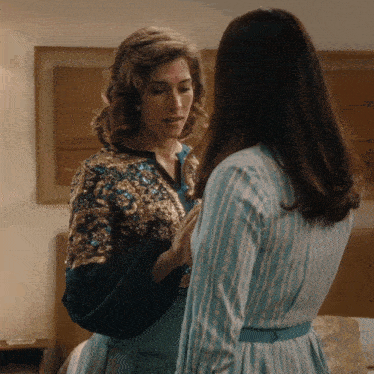 two women are standing next to each other and one is wearing a sequined jacket