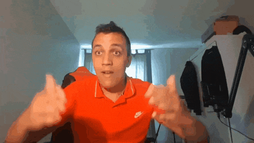 a man wearing a red nike polo shirt is making a funny face