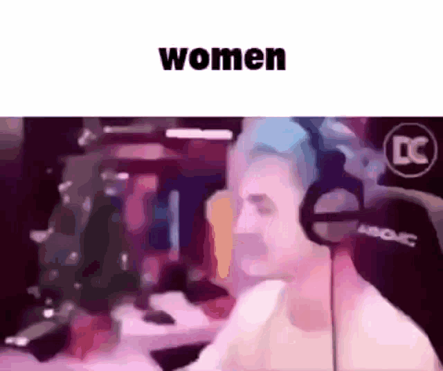 a man wearing headphones is sitting in front of a computer screen with the words `` women '' above him .