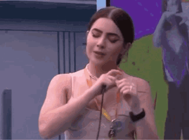 a woman is singing into a microphone while wearing a watch .