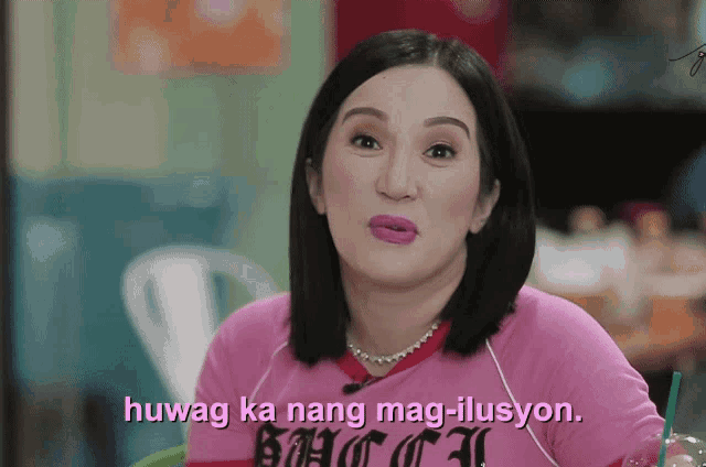 a woman wearing a pink shirt that says " huwag ka nang mag-illusion "