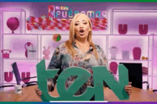 a woman is holding a green letter tn