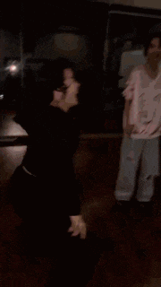 a woman wearing headphones is dancing in a dance studio