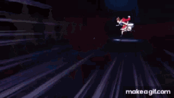 a girl in a red dress is flying through the air in a dark room .