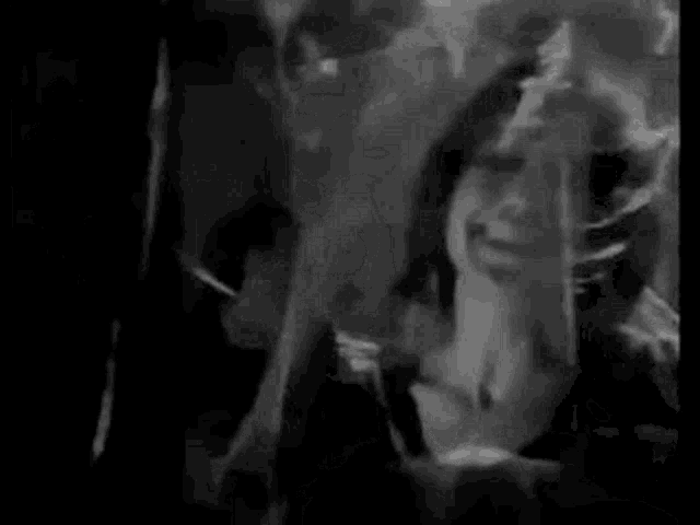a black and white photo of a woman dancing in a club .