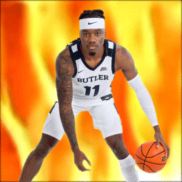 a basketball player wearing a butler jersey is holding an orange basketball