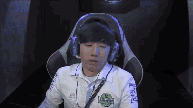a man wearing headphones and a white shirt with wings on it
