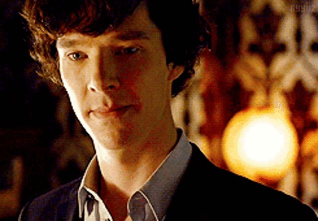 a close up of a man 's face with a light in the background and the word sherlock on the bottom
