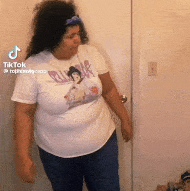 a woman wearing a white t-shirt with a picture of a woman with a sword on it