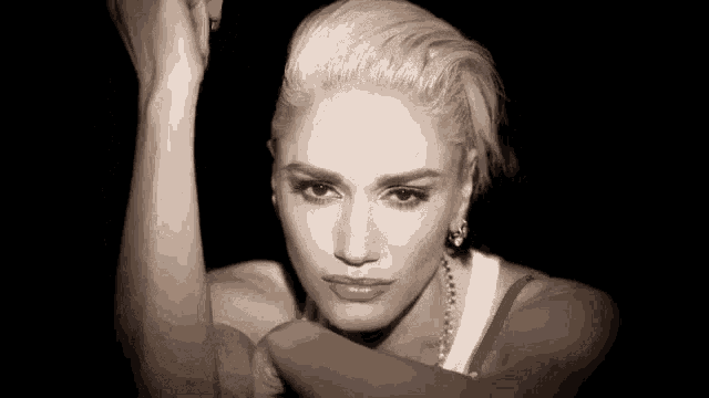 a close up of a woman 's face with her arms up