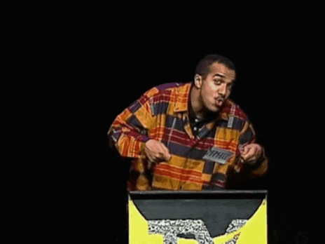 a man in a plaid shirt stands behind a podium with a leopard on it .