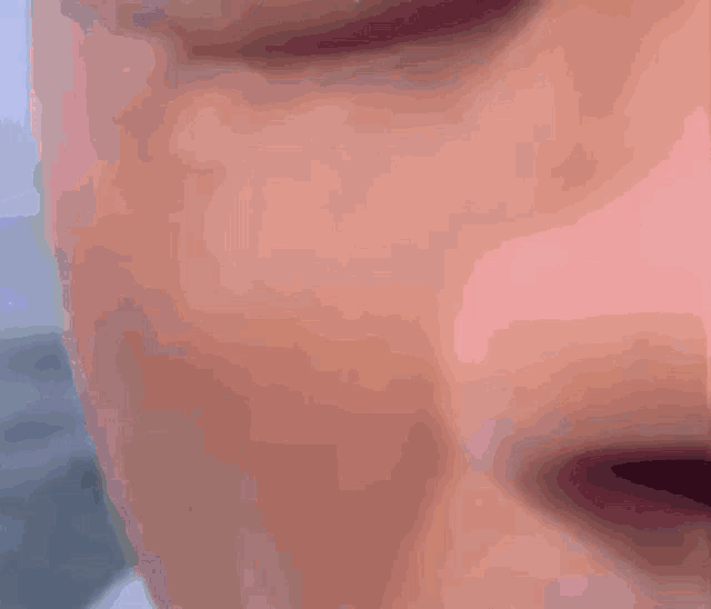 a close up of a person 's face with a slight smile