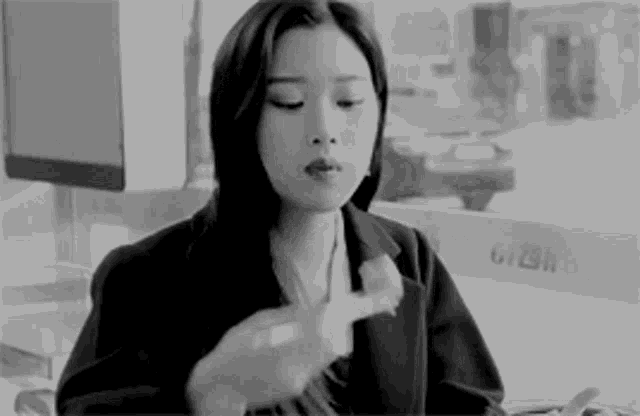 a woman in a suit is sitting at a table eating a chicken .