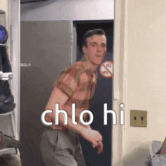a man in a plaid shirt is standing in a doorway with the words chlo hi written on the wall .