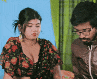 a man and a woman are sitting next to each other and the woman has a very large breast