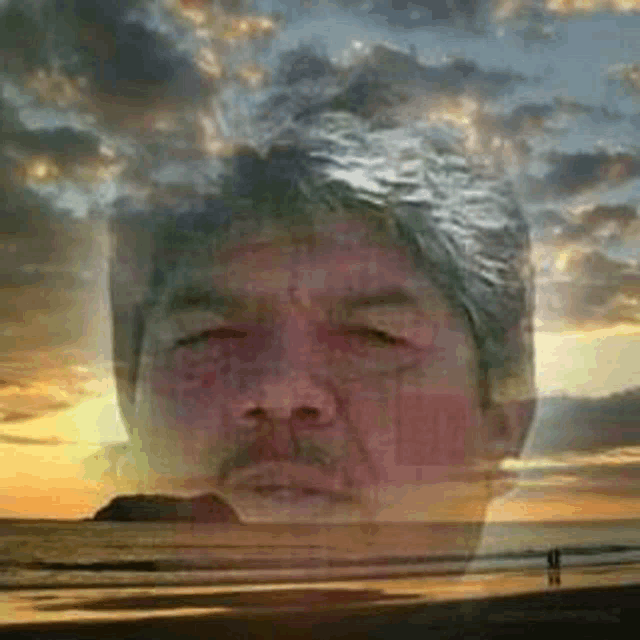 a man 's face is visible in a double exposure of a sunset and a beach .