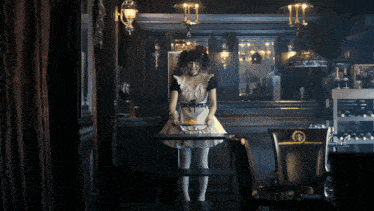 a woman in a maid costume holds a tray of food