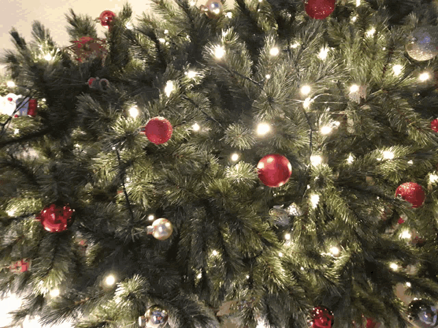a christmas tree is decorated with red and silver ornaments