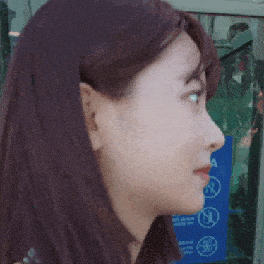 a close up of a woman 's face in front of a no smoking sign .