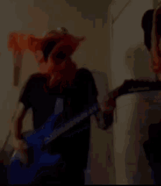 a woman with red hair is playing a blue guitar in a room .