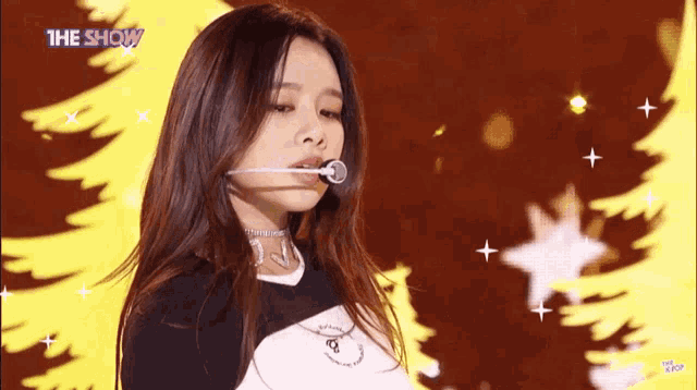 a girl singing into a microphone with the show written on the bottom