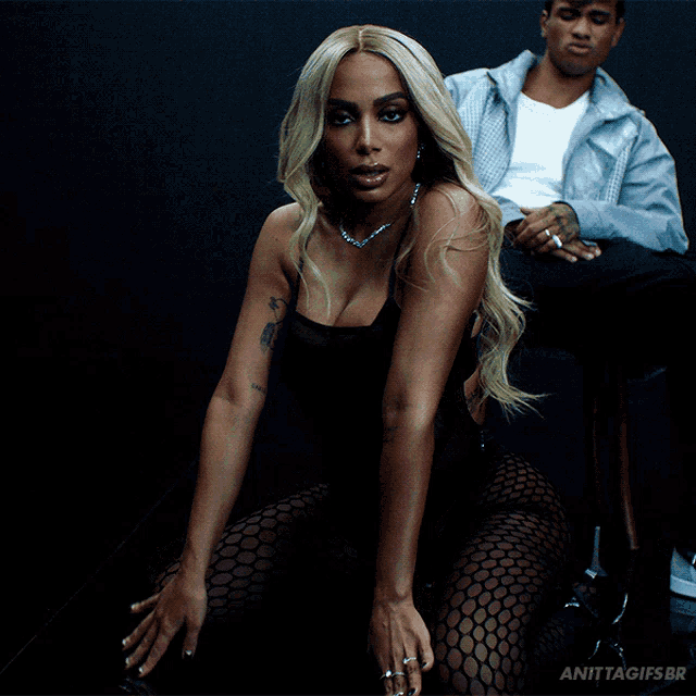 a woman in a black bodysuit sits next to a man in a white shirt and the words anittagifs.br are visible