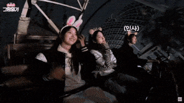 a girl wearing bunny ears is riding a roller coaster