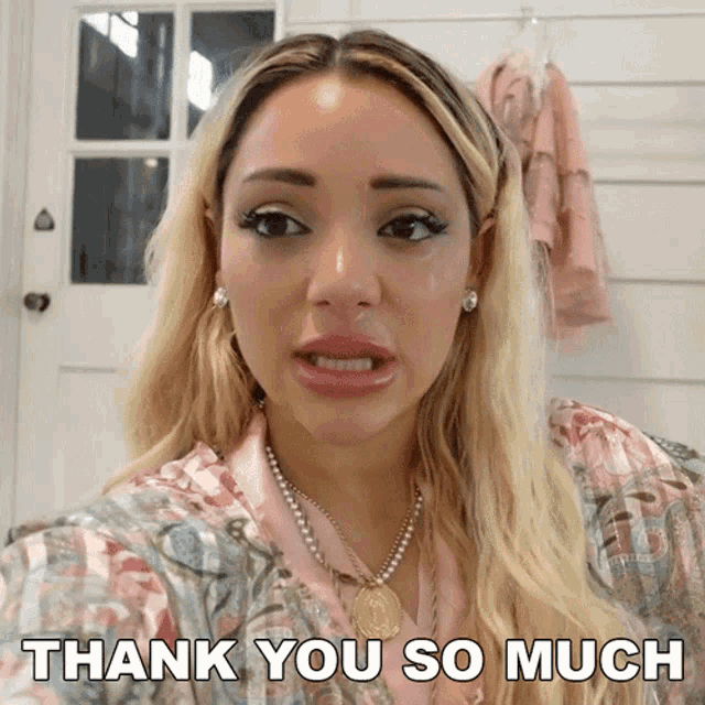a woman says " thank you so much " while wearing a necklace