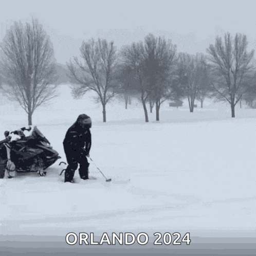 a man on a snowmobile is playing hockey in the snow with the words orlando 2024 below him