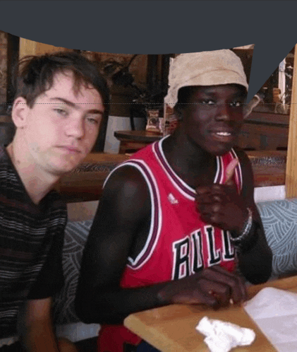 a man wearing a bulls jersey sits at a table with another man