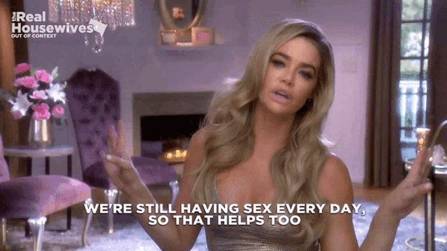 a woman says " we 're still having sex every day so that helps too " in front of a fireplace