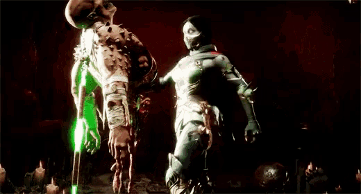 a man is hanging upside down with blood coming out of his neck while a woman stands behind him .