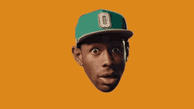 a man in a green hat is sticking his tongue out .