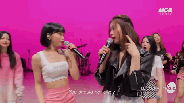 a woman singing into a microphone with the words " you should get away " behind her