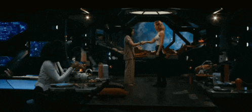 a woman shakes hands with another woman in a room with a monitor that says ' a ' on it