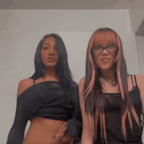 two girls are posing for a picture and one has glasses