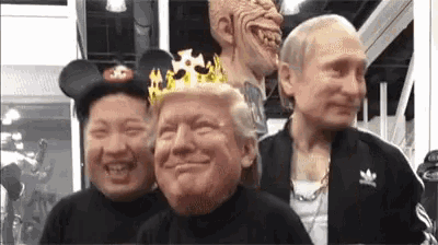 a group of people are posing for a picture with donald trump 's face on their heads .