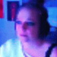 a blurry picture of a woman wearing headphones in a room with blue lights .