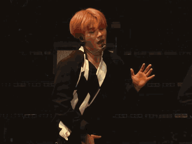 a man with red hair is standing in front of a microphone