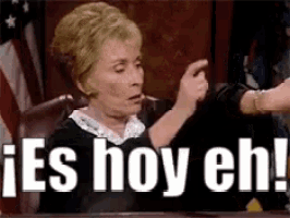 a woman is sitting in a judge 's chair and pointing at another woman .