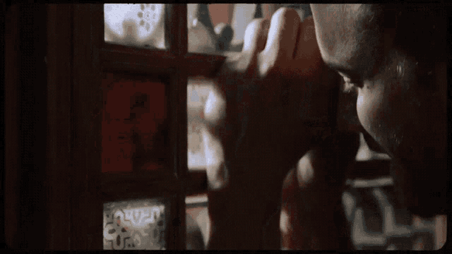 a close up of a man 's face with his hands on his face
