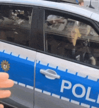 a police officer is driving a car with the word police on the side