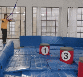 a boy in a yellow shirt is standing on a trampoline with numbers 1 and 3 on it