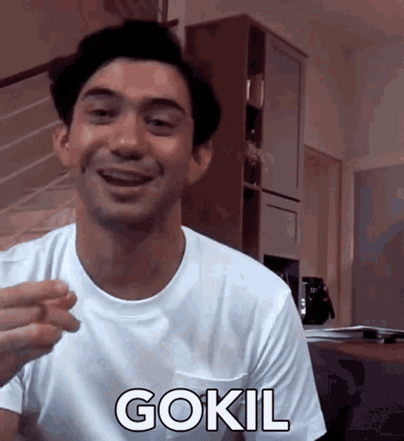 a man in a white shirt with the word gokil written on it