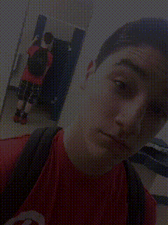 a young man in a red shirt is taking a picture of himself