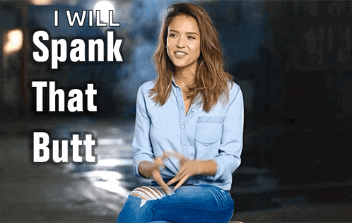 a woman in a blue shirt is sitting in front of a sign that says " i will spank that butt "